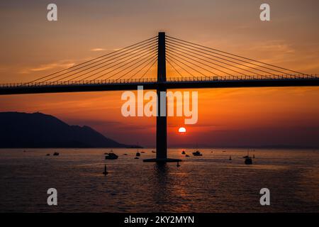 Die Sonne untergeht über der Peljesac-Brücke während der Eröffnungsfeier der Peljesac-Brücke am 26. Juli 2022 in Komarna, Kroatien. Foto: Zvonimir Barisin/PIXSELL Stockfoto