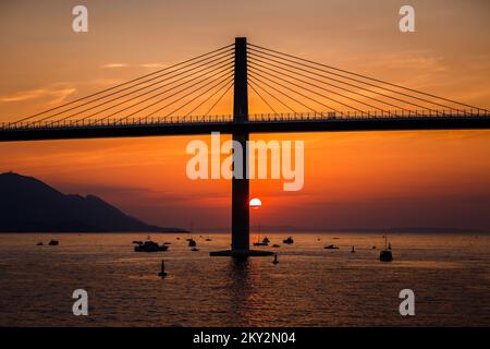 Die Sonne untergeht über der Peljesac-Brücke während der Eröffnungsfeier der Peljesac-Brücke am 26. Juli 2022 in Komarna, Kroatien. Foto: Zvonimir Barisin/PIXSELL Stockfoto