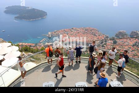 Zahlreiche Touristen kommen mit der Seilbahn auf den Srdj Hügel, wo sie am 11. August 2022 einen schönen Blick auf Dubrovnik, Kroatien, genießen. Stockfoto