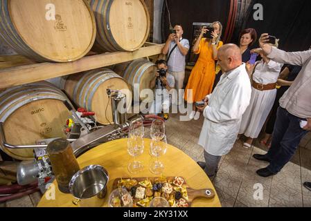 Chefarzt Damir Risek mit Journalisten vor der Eröffnung des Großen Barrel der Erdut-Weinberge in Erdut, Kroatien, am 11. August 2022. Das große Barrel der Erdut-Weinberge ist das größte Weinfass der Welt. Das Fassungsvermögen beträgt 75.000 Liter, was 100.000 Flaschen Wein entspricht. Das Fass ist mit zweieinhalb Tonnen Fesseln gekettet, dekoriert mit kroatischen Korbreliefs, sowie das Letzte Abendmahl, wo Jesus einen Kelch Wein hält, und wurde von naiven Bildhauern Tijardovic und Fodor dekoriert. Es besteht aus 150 Jahre alter slawischer Eiche und wurde 1989 von DIK Djurdjenovac hergestellt. Th Stockfoto