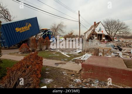 Staten Island, New York, 20. Dezember 2012, USA Das Army Corps of Engineers (USACE) entfernt die Überreste eines Hauses in Staten Island, NY, das während des Hurricane Sandy von seinem Fundament flog und sich mitten auf der Straße niederließ und den Verkehr blockierte. Nur der zweite Stock und Dachboden bleiben nach dem Sturm. Das Public Assistance Program der FEMA ermöglicht die Entfernung von Schutt aus öffentlichem Eigentum, um Gesundheits- und Sicherheitsrisiken zu beseitigen. Andrea Booher/FEMA. New York Hurrikan Sandy. Fotos zu Katastrophen- und Notfallmanagementprogrammen, Aktivitäten und Beamten Stockfoto