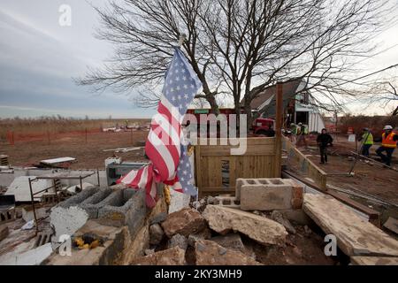 Staten Island, New York, 20. Dezember 2012, USA Das Army Corps of Engineers (USACE) entfernt die Überreste eines Hauses in Staten Island, NY, das während des Hurricane Sandy von seinem Fundament flog und sich mitten auf der Straße niederließ und den Verkehr blockierte. Nur der zweite Stock und Dachboden bleiben nach dem Sturm. Die FEMA stellt öffentliche Hilfsgelder für die Sanierung und Wiederherstellung von Stadtvierteln bereit, die von den Schäden durch Gezeitenstürme in Staten Island, New York, betroffen sind. Andrea Booher/FEMA. New York Hurrikan Sandy. Fotos zu Katastrophen- und Notfallmanagementprogrammen, Aktivitäten und von Stockfoto