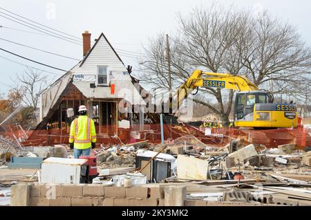 Staten Island, New York, 20. Dezember 2012 das Army Corps of Engineers entfernt die Überreste eines Hauses in Staten Island, New York, das während des Hurricane Sandy von seinem Fundament flog und sich in der Mitte der Straße niederließ und den Verkehr blockierte. Nur der zweite Stock und Dachboden bleiben nach dem Sturm. Die FEMA stellt öffentliche Hilfsmittel zur Verfügung, um die von Gezeitenwetterschäden betroffenen Viertel von Staten Island, NY, zu sanieren und wiederherzustellen. Andre R. Aragon/FEMA. New York Hurrikan Sandy. Fotos zu Katastrophen- und Notfallmanagementprogrammen, Aktivitäten und Beamten Stockfoto