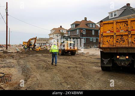 Mantoloking, N.J., 16. Januar 2013 Arbeiter von Versorgungsunternehmen arbeiten daran, Wasser- und Abwasserleitungen zu reparieren und mit schweren Maschinen abgelagerten Sand von Küstenstraßen zu entfernen, um Hauseigentümer, die vom Hurrikan Sandy betroffen waren, mit Versorgungsleistungen zu versorgen. Während der Wiederaufbauphase werden öffentliche Unterstützungsmaßnahmen der Kategorie A (Beseitigung von Trümmern) und der Kategorie F durchgeführt, um die Arbeiten im Zusammenhang mit dem Hurrikan zu finanzieren. Adam DuBrowa/FEMA. Hurrikan Sandy Aus New Jersey. Fotos zu Katastrophen- und Notfallmanagementprogrammen, Aktivitäten und Beamten Stockfoto