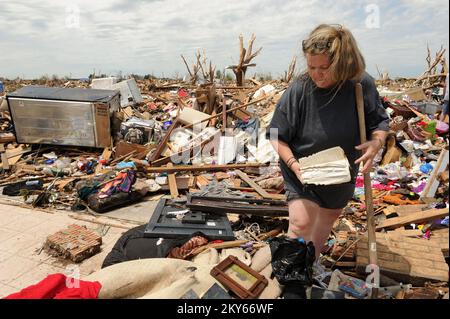 Moore, Okla., 23. Mai 2013 die einheimische Bewohnerin Trina Minnick findet eine bibel, während sie die Überreste ihres Hauses durchsucht, die bei dem letzten Tornado zerstört wurde, der am 20. Mai 2013 zuschlug. Einwohner, die vom Tornado betroffen sind, werden aufgefordert, sich bei der FEMA anzumelden. Moore, OK, 23. Mai 2013--Einheimische Trina Minnick findet eine bibel, während sie die Überreste ihres Hauses durchsucht, die bei dem Tornado zerstört wurde, der am 20. Mai 2013... Fotos zu Katastrophen- und Notfallmanagementprogrammen, Aktivitäten und Beamten Stockfoto