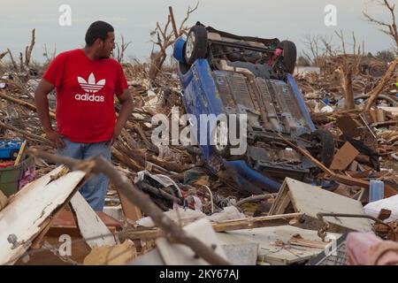 Moore, Okla., 23. Mai 2013 Bewohner von Moore, Axel Gudino blickt zurück auf das Auto eines Nachbarn, das vom Tornado über ein Haus geworfen wurde. Die Moore Gegend wurde am 20.. Mai von einem Tornado um F5 Uhr getroffen. Andrea Booher/FEMA... Fotos zu Katastrophen- und Notfallmanagementprogrammen, Aktivitäten und Beamten Stockfoto