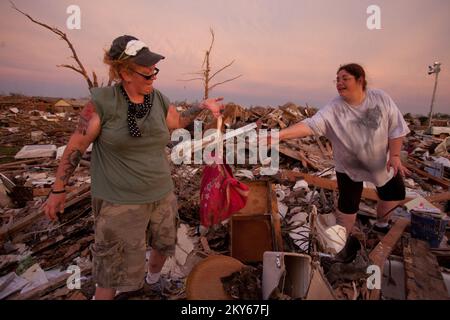 Moore, Okla., 23. Mai 2013, Bewohner von Moore, Kristian Parrish überreicht eine Tasche mit geborgenen Sachen an Freundin Kathryn Hudgins. Die Gegend von Moore, Oklahoma, wurde am 20.. Mai von einem Tornado um F5 Uhr getroffen. Andrea Booher/FEMA... Fotos zu Katastrophen- und Notfallmanagementprogrammen, Aktivitäten und Beamten Stockfoto