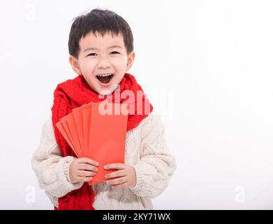 Aufgeregter asiatischer Junge, der viele rote Umschläge zeigt und in der Hand hält. Frohes Chinesisches Neujahrskonzept. Stockfoto