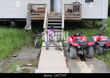 Alakanuk, Alaska, 16. Juli 2013 Kinder schwammen über den Gaumen bis zu ihrer Haustür, nachdem eine schwere Flut Wasser um den Umkreis dieses Hauses hinterlassen hat. Staatliche Mittel in Form von öffentlicher Unterstützung (PA) und individueller Unterstützung (IA) stehen staatlichen, Stammesregierungen und berechtigten Kommunalverwaltungen sowie bestimmten gemeinnützigen Organisationen zur Verfügung. Adam DuBrowa/FEMA. Fotos zu Katastrophen- und Notfallmanagementprogrammen, Aktivitäten und Beamten Stockfoto