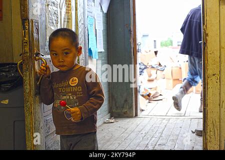 Alakanuk, Alaska, 16. Juli 2013 Little Jameson Ayunerak spielt, während Trümmer aus dem örtlichen Gemischtwarenladen entfernt werden, nachdem eine schwere Flut diese Gemeinde verwüstet hat. Die FEMA reagiert und verfügt über ein Team, das mit dem Staat Alaska und den benannten indianischen Stämmen zusammenarbeitet, um Geschäftsinhabern und Einzelpersonen dabei zu helfen, sich von den Auswirkungen der Katastrophe zu erholen. Adam DuBrowa/FEMA. Fotos zu Katastrophen- und Notfallmanagementprogrammen, Aktivitäten und Beamten Stockfoto