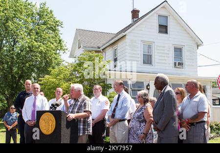 South River, N.J., 16. Juli 2013 Bob Smith, Einwohner von South River, spricht darüber, wie Hurrikan Sandy sein Haus zerschmettert hat, als Hintergrund für diese Pressekonferenz, jenseits von Reparaturen bei der Regierung. Christies Überflutungsankündigung. Der Staat kauft Hurrikan Sandy beschädigte Immobilien in Middlesex County, die die Federal Emergency Management Agency teilweise finanziert hat. Hurrikan Sandy Aus New Jersey. Fotos zu Katastrophen- und Notfallmanagementprogrammen, Aktivitäten und Beamten Stockfoto