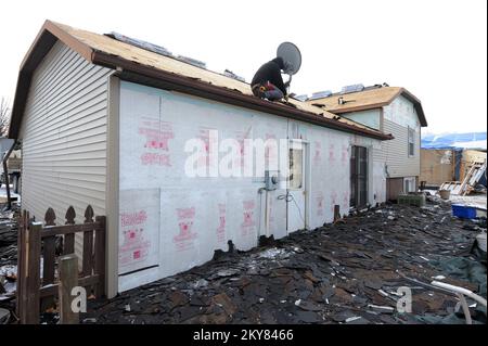 Pekin, Illinois, 9. Dezember 2013, Eine Crew repariert ein Dach, das beim letzten Tornado beschädigt wurde. Betroffene Einwohner werden aufgefordert, sich bei der FEMA anzumelden, indem sie sich telefonisch unter (800) 621-3362, (TTY) (800) 462-7585 oder online unter www.DisasterAssistance.gov registrieren. Pekin, Illinois, 9. Dezember 2013--Eine Mannschaft arbeitet an der Reparatur eines Dachschadens während des kürzlichen Tornados. Betroffene Einwohner werden aufgefordert, sich bei FEMA anzumelden, indem sie sich telefonisch unter (800) 621-3362, (TTY) (800) 462-7585 oder online unter www.DisasterAssistance.gov registrieren. Fotos zu Katastrophen- und Notfallmanagementprogrammen, Aktivitäten und Offic Stockfoto