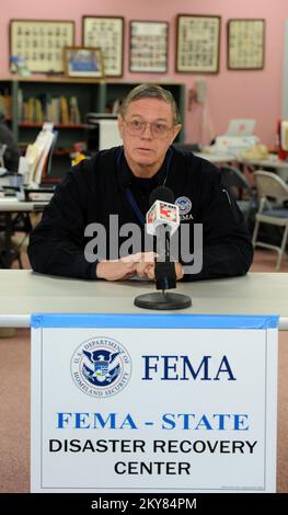 Brookport, Illinois, 12. Dezember 2013, FEMA Federal Coordinating Officer Donald Keldsen, spricht auf einer Pressekonferenz in einem Disaster Recovery Center, das in der Bibliothek eingerichtet wurde. Einwohner, die vom Tornado am 17. November 2013 betroffen sind, werden gebeten, sich bei der FEMA unter der Nummer (800) 621-3362, (TTY) (800) 462-7585 oder online unter www.DisasterAssistance.gov um Unterstützung zu bewerben. Brookport, ILL, 12. Dezember 2013 – FEMA Federal Coordinating Officer Donald Keldsen, spricht auf einer Pressekonferenz in einem Disaster Recovery Center, das in der Bibliothek eingerichtet wurde. Fotografien zu Katastrophen- und Notfallmanagementprogrammen, Betrieb Stockfoto