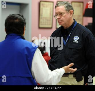 Brookport, Illinois, 12. Dezember 2013 FEMA Federal Coordinating Officer Donald Keldsen, rechts, spricht mit einem Applicant Services Program Specialist in einem Recovery Center, das in der Bibliothek eingerichtet wurde. Einwohner, die vom Tornado am 17. November 2013 betroffen sind, werden gebeten, sich bei der FEMA unter der Nummer (800) 621-3362, (TTY) (800) 462-7585 oder online unter www.DisasterAssistance.gov um Unterstützung zu bewerben. Brookport, ILL, 12. Dez. 2013-FEMA Federal Coordinating Officer Donald Keldsen, rechts, spricht mit einem Applicant Services Program Specialist in einem Recovery Center, das in der Bibliothek eingerichtet wurde. Fotos von Katastrophen A Stockfoto