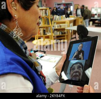 Brookport, Illinois, 12. Dezember 2013, FEMA Applicant Services Program Specialist Maria Gabel, demonstriert ein iPad, das für Taube oder hörgeschädigte Bewerber in einem Recovery Center in der Bibliothek eingerichtet wurde. Einwohner, die vom Tornado am 17. November 2013 betroffen sind, werden gebeten, sich bei der FEMA unter der Nummer (800) 621-3362, (TTY) (800) 462-7585 oder online unter www.DisasterAssistance.gov um Unterstützung zu bewerben. Brookport, ILL, 12. Dezember 2013 – FEMA Applicant Services Program Specialist Maria Gabel, demonstriert ein IPAD, das für Taube oder hörgeschädigte Bewerber in einem Recovery Center eingerichtet ist, das in t eingerichtet ist Stockfoto