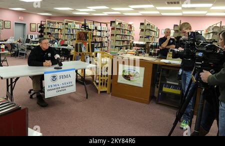 Brookport, Illinois, 12. Dezember 2013 FEMA Federal Coordinating Officer Donald Keldsen, Left, spricht auf einer Pressekonferenz in einem Disaster Recovery Center, das in der Bibliothek eingerichtet wurde. Einwohner, die vom Tornado am 17. November 2013 betroffen sind, werden gebeten, sich bei der FEMA unter der Nummer (800) 621-3362, (TTY) (800) 462-7585 oder online unter www.DisasterAssistance.gov um Unterstützung zu bewerben. Brookport, ILL, 12. Dezember 2013 – FEMA Federal Coordinating Officer Donald Keldsen, Left, spricht auf einer Pressekonferenz in einem Disaster Recovery Center, das in der Bibliothek eingerichtet wurde. Fotografien zu Katastrophen und Notfallmanagement Prog Stockfoto