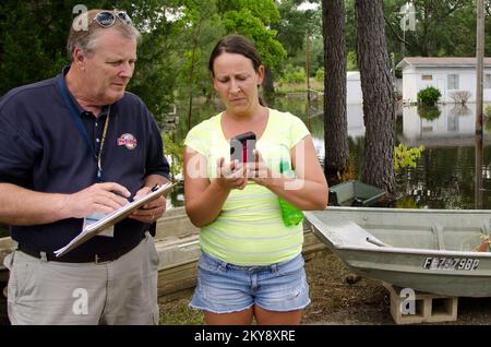 Pensacola, FL, 12. Mai 2014 während einer Schadensbeurteilung in Jackson County, Florida, Mitglied des State Emergency Response Team (SERT), sieht Alvin Bishop Fotos von Brandy Dudleys durch Flut beschädigtem Haus. Sintflutartiger Regen durch ein Paar Gewitter löste große Überschwemmungen an Teilen des Florida Panhandle aus. Andrea Booher/FEMA. Schwere Stürme, Tornados, Stürme und Überschwemmungen in Florida. Fotos zu Katastrophen- und Notfallmanagementprogrammen, Aktivitäten und Beamten Stockfoto