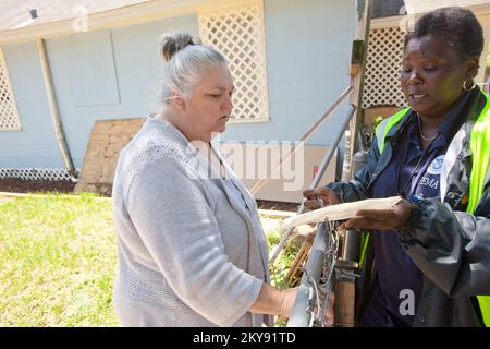 Pensacola, FL, 15. Mai 2014 Mitglied des FEMA Disaster Survivor Assistance Team (DSAT), Loretta Wesley überprüft die FEMA-Registrierung der Katastrophenüberlebenden Toni Talley in ihrem Haus in der Brownsville Nachbarschaft Pensacola, Florida. Nach großen Überschwemmungen entlang Teilen des Florida Panhandle wurden DSAT-Teams eingesetzt, um die Nachbarschaften mit Informationen über Katastrophen zu befragen und von Tür zu Tür zu gehen, um das Wohlergehen der Überlebenden von Katastrophen zu überprüfen. Andrea Booher/FEMA. Schwere Stürme, Tornados, Stürme und Überschwemmungen in Florida. Fotografien zu Katastrophen- und Notfallmanagementprogrammen, Stockfoto