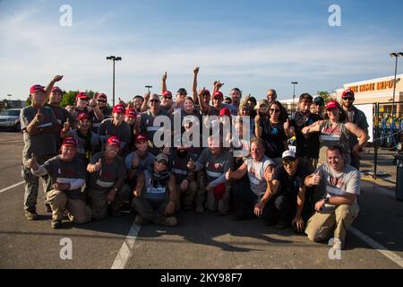 "Conway, AR, 20. Mai 2014; Freiwillige von Team Rubicon treffen sich nach einem Tag ehrenamtlicher Tätigkeit in den Gemeinden Mayflower und Vilonia zu einem Gruppenfoto an ihrer Forward Operating Base (FOB) auf dem Parkplatz eines Home Depot in Conway, Arkansas, nach einem Tag ehrenamtlicher Tätigkeit in den Gemeinden Mayflower und Vilonia, Arkansas unterstützt Überlebende der Katastrophe bei der Beseitigung von Trümmern nach einem Tornado, der diese Gemeinden am 27. April traf. FEMA unterstützt gemeinnützige Organisationen, die aktiv in Katastrophen (VOAD) sind, um Überlebenden bei der Wiederherstellung nach Naturkatastrophen zu helfen. Arkansas schwere Stürme, Tornadoes und Überschwemmungen. Fotografien zu Katastrophen und Notfallmanagementprogrammen, A Stockfoto