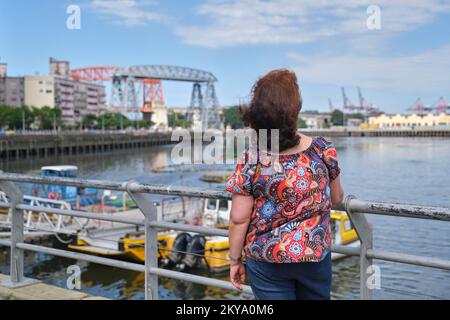 Nicht wiedererkennbare reife Frau, die von hinten in Richtung Riachuelo, im Touristenviertel La Boca, in Buenos Aires, Argentinien, auf A blickt Stockfoto