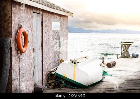 Rustikales Bootshaus an der Ostküste unter dem Morgenhimmel auf einem hölzernen Dock in Neufundland, Kanada. Stockfoto