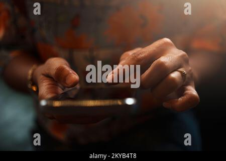 Nahaufnahme der Hand einer Frau mit einem Smartphone während der Kaffeepause. Stockfoto