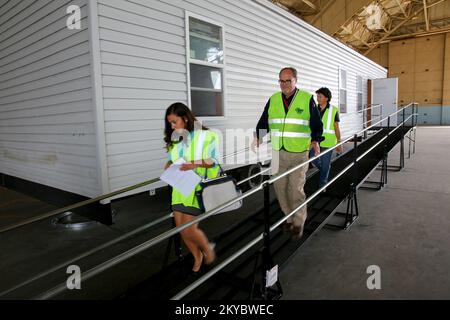 Mark Ackerman (C), FEMA Logistics Supervisor, erläutert der Außenvertreterin von Senator Boxer, Julissa Delgado (L), während einer Führung durch den Stauraum die vorübergehende Wohnungsmission. Da Mietwohnungen in beiden betroffenen Bezirken knapp sind, stellt die FEMA gefertigte Wohneinheiten (MHU) für berechtigte registrierte Überlebende in den ausgewiesenen Bezirken zur Verfügung. California Valley Fire und Butte Fire. Fotos zu Katastrophen- und Notfallmanagementprogrammen, Aktivitäten und Beamten Stockfoto