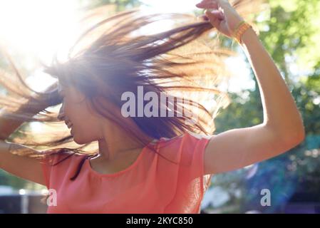 Tanz, als ob niemand zusieht. Eine Frau tanzt frei im Freien. Stockfoto