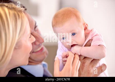 Sie ist einfach wertvoll. Nahaufnahme einer Mutter und eines Vaters, die ihr kleines Mädchen liebevoll ansehen. Stockfoto