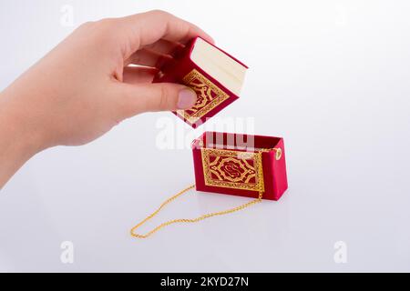 Hand, die der Heilige Koran auf weißem Hintergrund Stockfoto