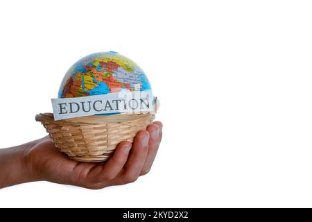 Bildung in einer Hand und Globus in einer Hand in einem Korb Stockfoto