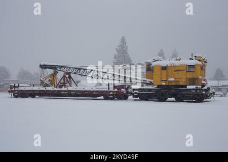 Ein BNSF American Hoist & Derrick Co., Modell 840 DE, 40-50 Tonnen, Diesel-Elektro-Lokomotivkran, im Schnee, Troja, Montana. Stockfoto
