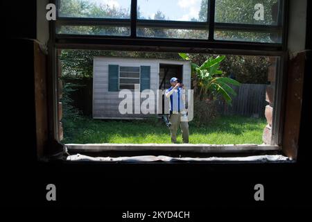 Christian White, Versicherungssachverständiger, macht Außenfotos von einem durch Flutkatastrophen geschädigten Haus während seiner Bewertung in East Baton Rouge Parish, La. Schwere Stürme und Überschwemmungen in Louisiana. Fotos zu Katastrophen- und Notfallmanagementprogrammen, Aktivitäten und Beamten Stockfoto