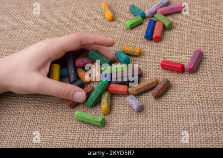 Benutzte Farbstifte und eine Hand, die etwas hielt Stockfoto