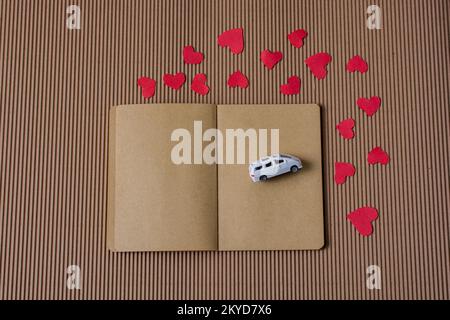 Love Concept mit Auto- und Herzpapieren im Botebook Stockfoto