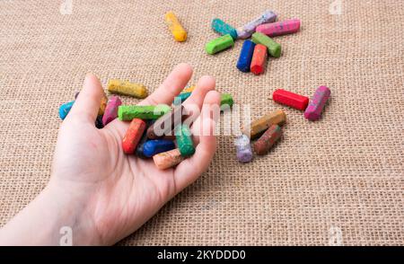 Benutzte Farbstifte und eine Hand, die etwas hielt Stockfoto