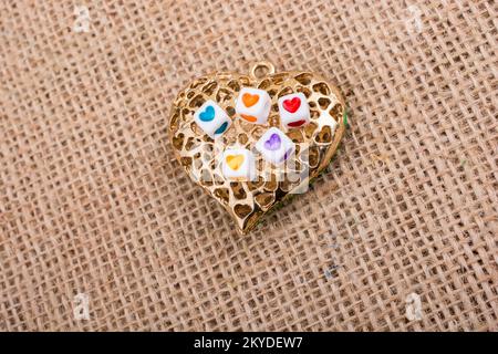 Herzwürfel auf herzförmigem goldenen Objekt Stockfoto