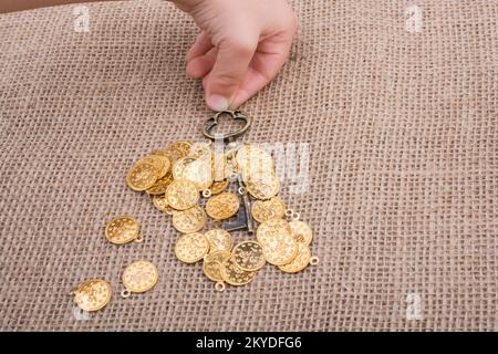 Hand mit einem retro styled über gefälschte Goldmünzen Stockfoto