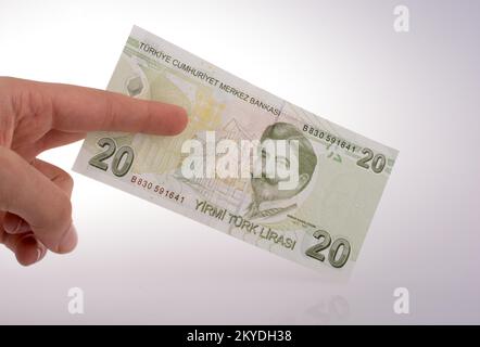 Hand mit Turksh Lira-Banknote auf weißem Hintergrund Stockfoto