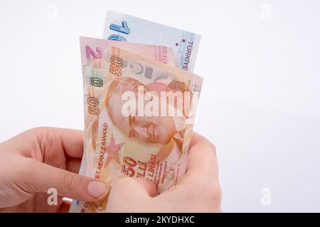 Hand hält die Turksh Lira Banknoten auf weißem Hintergrund Stockfoto