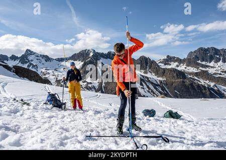 Suchen Sie mit dem Lawinen-Transceiver und der Sonde nach begrabenen Personen, Risikomanagement, Lawinenbewusstsein, Lawinensuche im Winter im Stockfoto