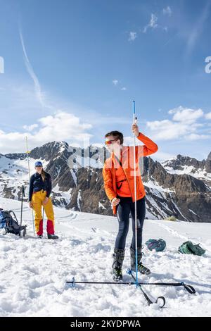 Suchen Sie mit dem Lawinen-Transceiver und der Sonde nach begrabenen Personen, Risikomanagement, Lawinenbewusstsein, Lawinensuche im Winter im Stockfoto