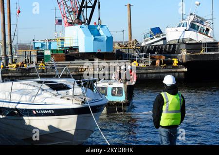 Perth Amboy, N.J., 27. März 2013 viele Boote wurden letzten Oktober durch Hurrikan Sandy beschädigt und liegengelassen entlang der Wasserstraßen oder an den Stränden der New Jersey Shore. Am Fuße der 2.. Straße in Perth Amboy kam eine Crew, um ein Boot zu entfernen, das als verlassen identifiziert wurde. Die FEMA arbeitet mit dem New Jersey Department of Environmental Protection und anderen Partnern zusammen, um die Beseitigung dieser Arten von Gefahren zu erleichtern. Hurrikan Sandy Aus New Jersey. Fotos zu Katastrophen- und Notfallmanagementprogrammen, Aktivitäten und Beamten Stockfoto