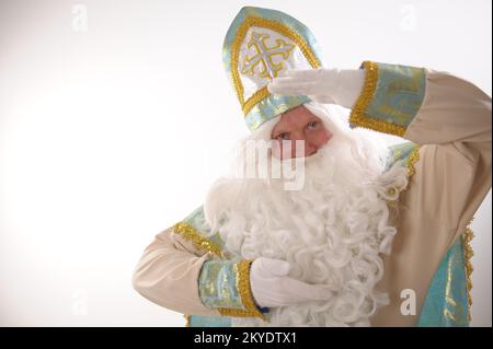 Sinterklaas porträtiert USA auf weißem Hintergrund. Holländischer Weihnachtsmann St. Nikolaus weihnachten Neujahr weißer Bart und goldblauer Anzug von St. Nikolaus auf weißem Hintergrund in der Studiowerbung Stockfoto