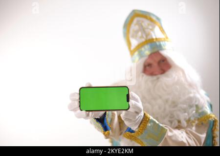 Sinterklaas porträtiert USA auf weißem Hintergrund. Holländischer Weihnachtsmann St. Nikolaus weihnachten Neujahr weißer Bart und goldblauer Anzug von St. Nikolaus auf weißem Hintergrund in der Studiowerbung Stockfoto