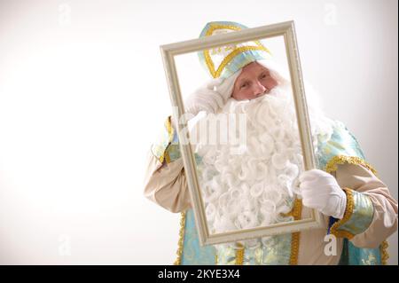 Sinterklaas porträtiert USA auf weißem Hintergrund. Holländischer Weihnachtsmann St. Nikolaus weihnachten Neujahr weißer Bart und goldblauer Anzug von St. Nikolaus auf weißem Hintergrund in der Studiowerbung Stockfoto