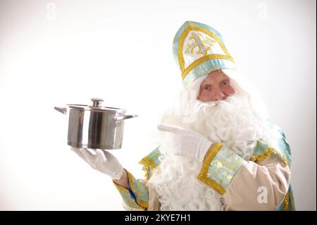 Sinterklaas-Porträt. USA auf weißem Hintergrund. Holländischer Weihnachtsmann St. Nicholas weihnachten Neujahr St. Nicholas mit einem Topf in den Händen bereitet Silvester-Essen für Weihnachten vor Stockfoto