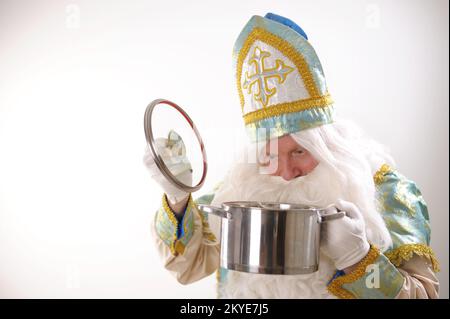 Sinterklaas-Porträt. USA auf weißem Hintergrund. Holländischer Weihnachtsmann St. Nicholas weihnachten Neujahr St. Nicholas mit einem Topf in den Händen bereitet Silvester-Essen für Weihnachten vor Stockfoto