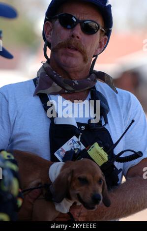 New Orleans, LA, 7. September 2005- Ein Mitglied der FEMA Urban Search and Rescue streichelt einen gestrandeten Hund, der in Gebieten gefunden wurde, die vom Hurrikan Katrina betroffen sind, wo die Teams den Betrieb wieder aufnehmen. Jocelyn Augustino/FEMA Stockfoto