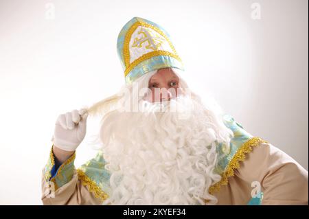 Sinterklaas-Porträt. USA auf weißem Hintergrund. Der niederländische Weihnachtsmann St. Nikolaus weihnachten Neujahr in den Händen von St. Nicholas, ein weißer Stift, denkt, was er schreiben soll, um Wünsche zu erfüllen Stockfoto